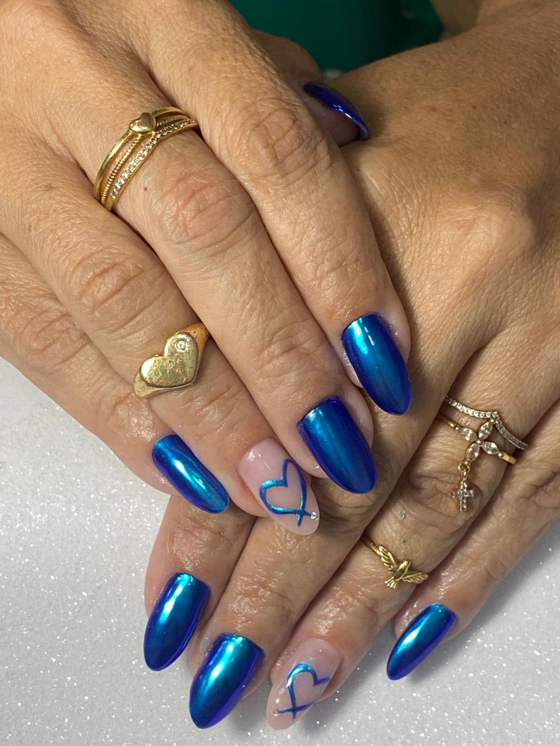 Unhas azuis metálicas com decoração em formato de coração